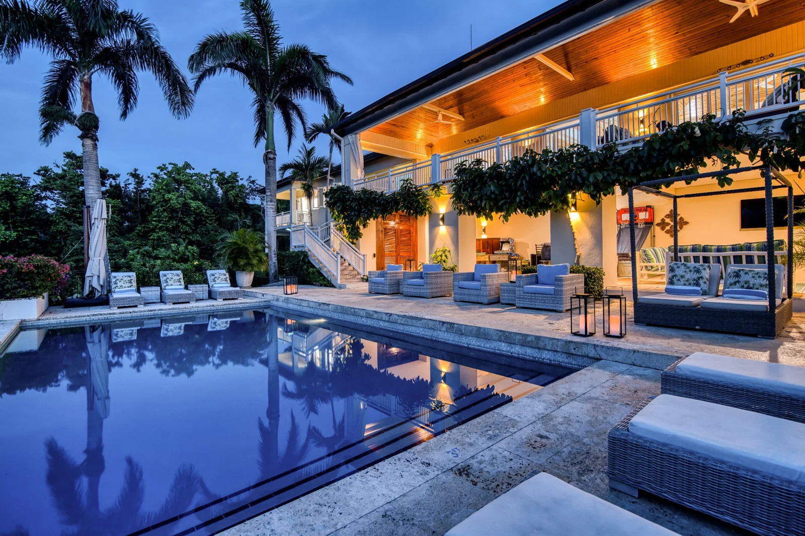 The villa and pool illuminated at dusk