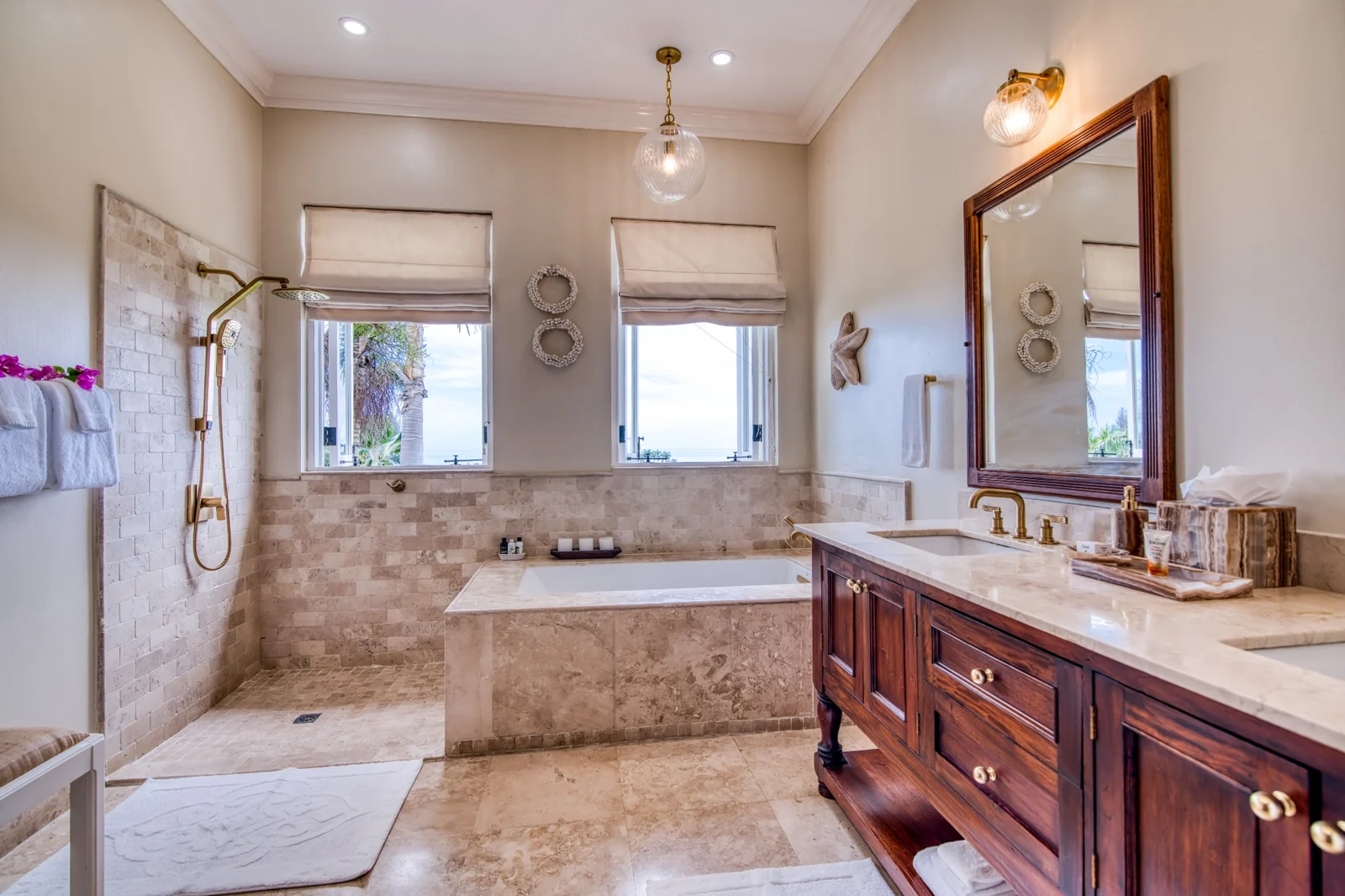 A marble master bathroom with double vanity and soaking tub