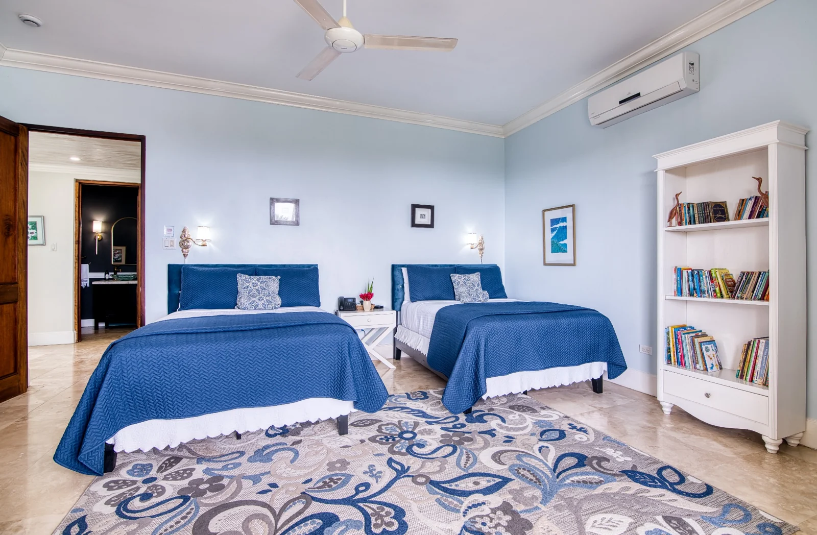 A bedroom with two blue upholstered beds